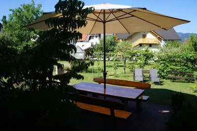 a picnic table with an umbrella in a yard at Apartma Tanya Bled in Bled