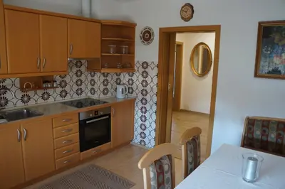 a kitchen with wooden cabinets and a table with a tableablish at Apartma Tanya Bled in Bled