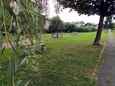 two picnic tables in a park with a tree at ECO-LUX APART with free bicycles end free parking in Ljubljana