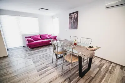 a living room with a table and chairs and a purple couch at CUDERLAND - Petra in Kobarid