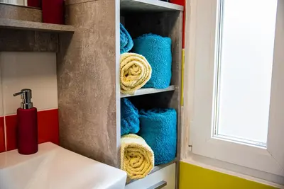 a bathroom with blue towels on a shelf at CUDERLAND - Petra in Kobarid