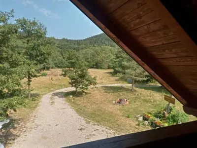 a view of a field from a house at Podklanci-house in the forest in Knežak