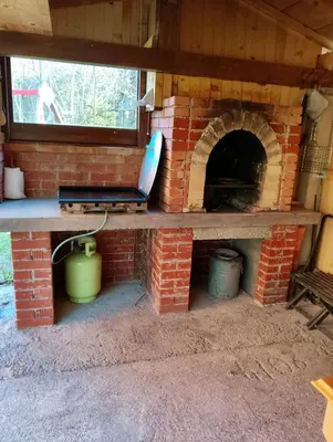 a brick oven with a laptop on top of it at Podklanci-house in the forest in Knežak