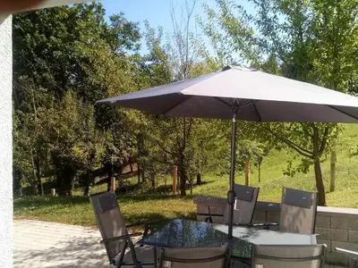 an umbrella sitting on top of a table with chairs at Grajsko in Metlika