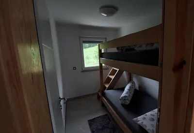 a small room with bunk beds and a window at Grajsko in Metlika