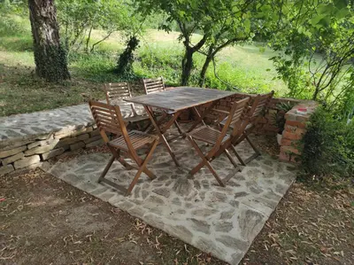 a wooden table and chairs on a stone wall at Park Istra holiday home in Koper