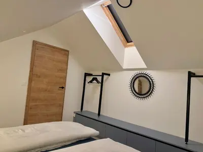 a bedroom with a bed and a mirror and a skylight at Soska 5 in Ljubljana