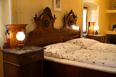 a bedroom with a large wooden bed with white sheets at Škerlj Wine Estate in Tomaj