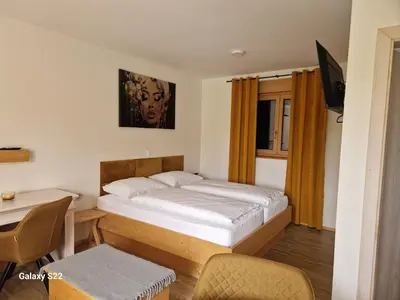 a bedroom with a bed and a desk and a table at Rooms & Wine Lilek in Šentilj