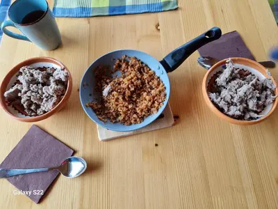 a table with a pan of food and two bowls of food at Rooms & Wine Lilek in Šentilj