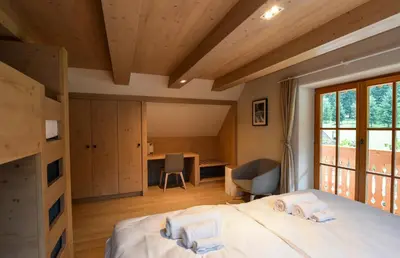 a bedroom with a bed and a desk in a room at JULIAN VILLAGE LEPENA in Soča