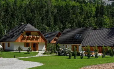 a group of houses in front of a mountain at JULIAN VILLAGE LEPENA in Soča