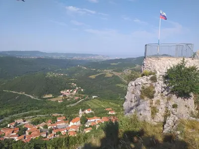 a flag on top of a mountain with a town at Relax Črni Kal 3 in Črni Kal