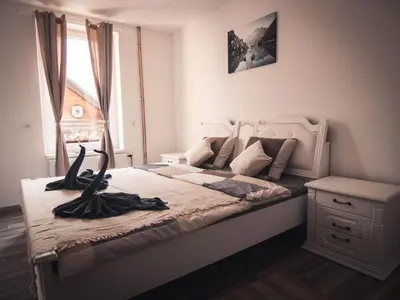 a bedroom with a large white bed with a large window at Apartments STARI TIGER in Bohinj