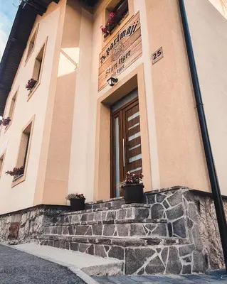 a building with potted plants on the steps at Apartments STARI TIGER in Bohinj