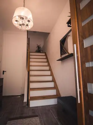 a staircase in a house with a chandelier at Apartments STARI TIGER in Bohinj