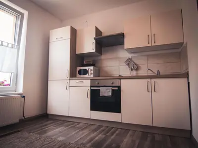 a kitchen with white cabinets and a stove at Apartments STARI TIGER in Bohinj