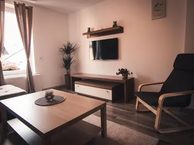 a living room with a coffee table and a tv at Apartments STARI TIGER in Bohinj