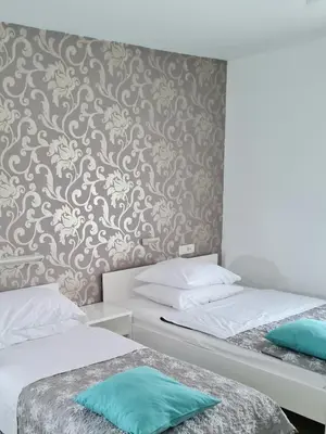 two twin beds in a room with a wall at AZUR ROOMS LJUBLJANA in Ljubljana