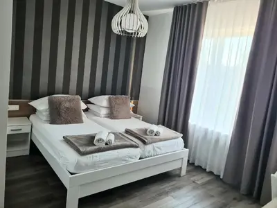a bedroom with a bed with towels and a chandelier at AZUR ROOMS LJUBLJANA in Ljubljana