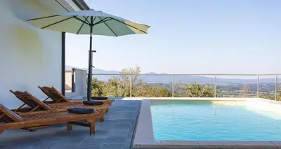 a swimming pool with two chairs and an umbrella at Villa Vitovlje in Vitovlje