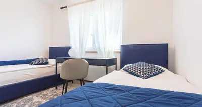 a bedroom with two beds and a desk and a chair at Villa Vitovlje in Vitovlje