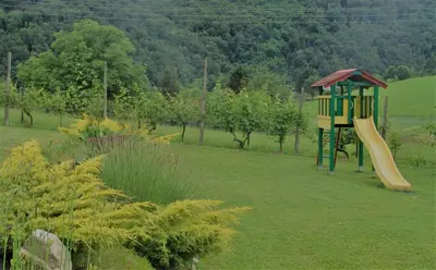 a playground with a slide in the middle of a field at Hiša Žičanka in Loče pri Poljčanah