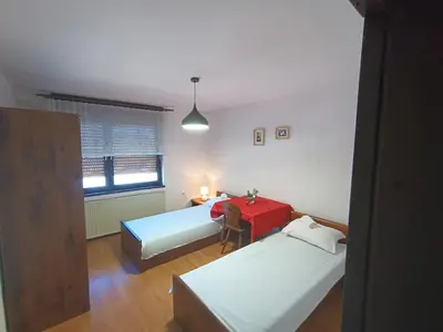a room with two beds and a red table at Hiša Žičanka in Loče pri Poljčanah