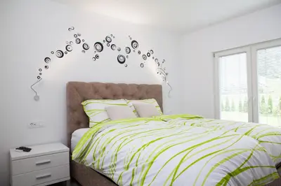a bedroom with a bed with a green and white comforter at Bella Belca in Mojstrana
