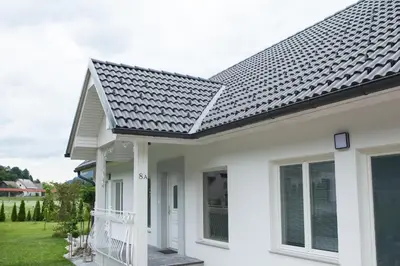 a white house with a black roof at Bella Belca in Mojstrana