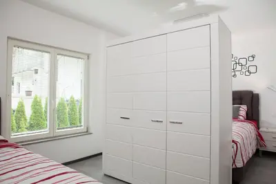 a white cabinet in a bedroom with a bed at Bella Belca in Mojstrana