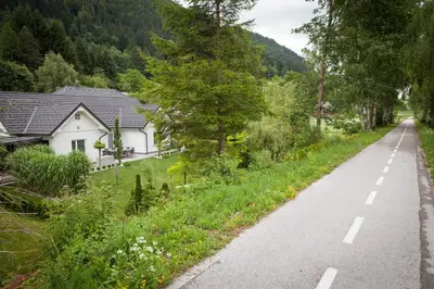 a road next to a white house and trees at Bella Belca in Mojstrana