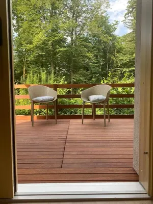 two chairs on a deck with a view of trees at STUDIO BELA in Radovljica