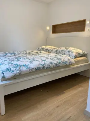 a bed with a blue and white comforter at STUDIO BELA in Radovljica