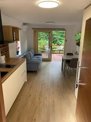 a kitchen and living room with a couch and a table at STUDIO BELA in Radovljica
