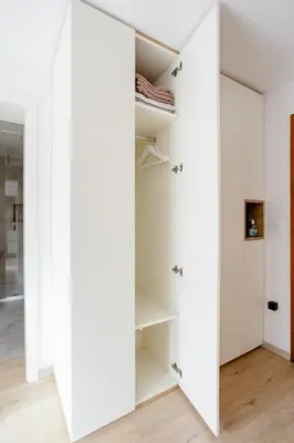 a room with white walls and a large mirror at STUDIO BELA in Radovljica