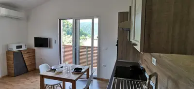 a small dining room with a table and a kitchen at Apartmaji Tmaynka in Tolmin