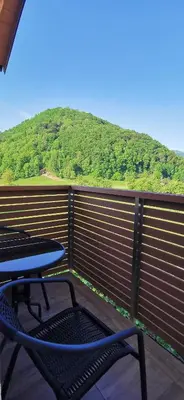 a table and chairs on a balcony with a mountain at Apartmaji Tmaynka in Tolmin