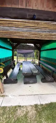 two benches sitting under a green building at Francek house Podčetrtek in Buče