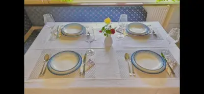 a table with a white table cloth and blue plates at Francek house Podčetrtek in Buče