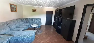 a living room with a blue couch and a flat screen tv at Francek house Podčetrtek in Buče