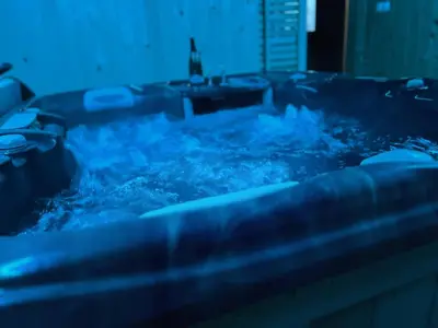 a bath tub filled with blue water in a bathroom at Apartma Ksela in Mala Nedelja