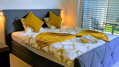 a large bed with yellow and white blankets and pillows at Point Zero in Ljubljana