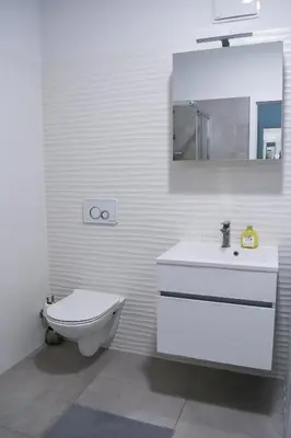 a bathroom with a toilet and a sink and a mirror at Point Zero in Ljubljana
