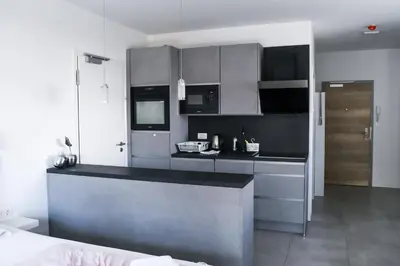 a kitchen with black and gray cabinets and a counter at Point Zero in Ljubljana