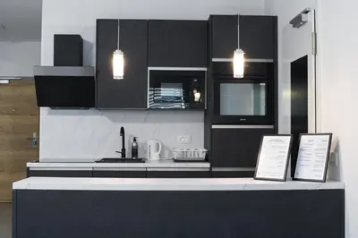 a kitchen with black cabinets and a counter top at Point Zero in Ljubljana