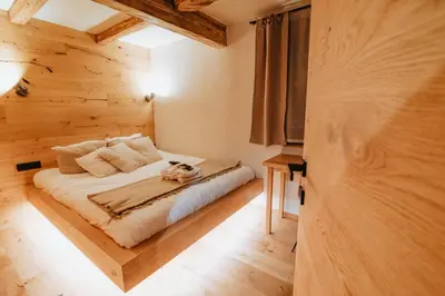 a bedroom with a bed with a cat sitting on it at Cottage Planska koča in Vitanje