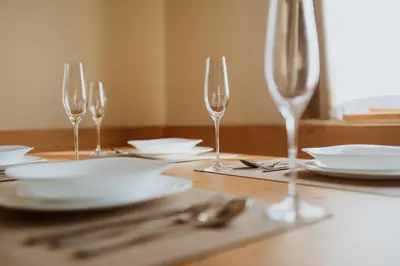 a table with wine glasses and plates on it at Cottage Planska koča in Vitanje
