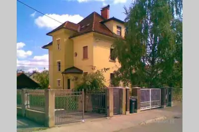 a yellow house with a fence in front of it at The Villa in Ljubljana