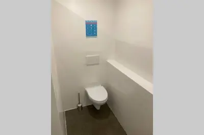 a white bathroom with a toilet with a blue sign at The Villa in Ljubljana